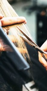 Hair Cut, Color, and Style Services, woman getting her hair cut, close up of stylist's hands